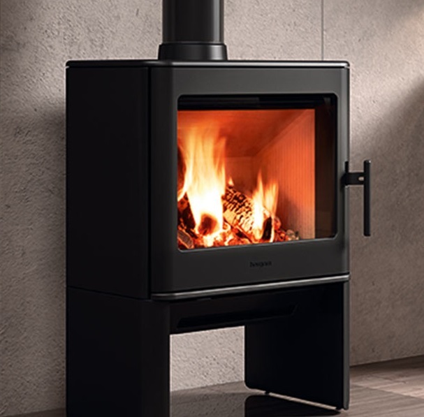 Hergom E-40 12kW freestanding fireplace in matte black shown against a concrete wall in a modern interior