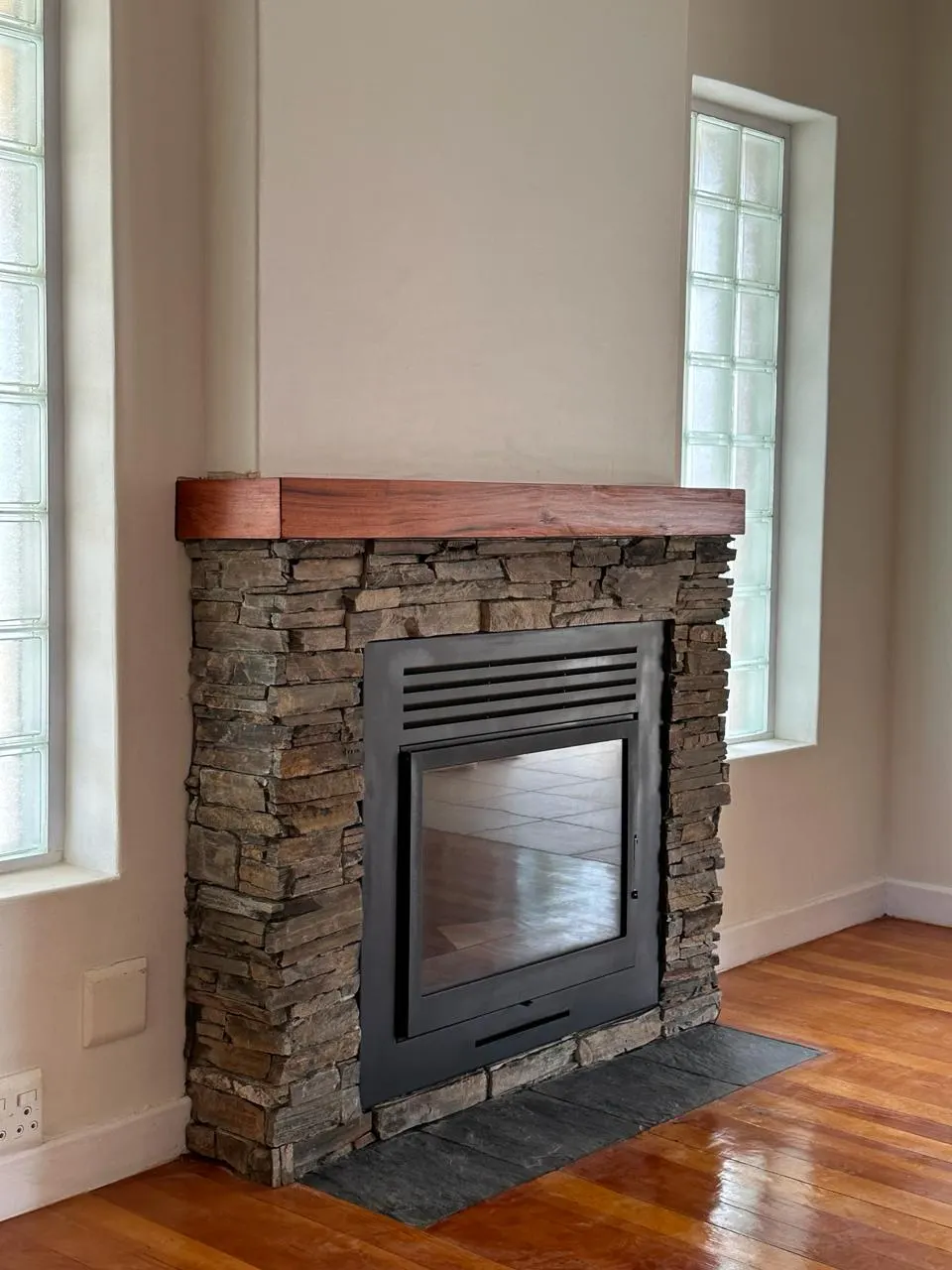 Finished fireplace with a timber mantel