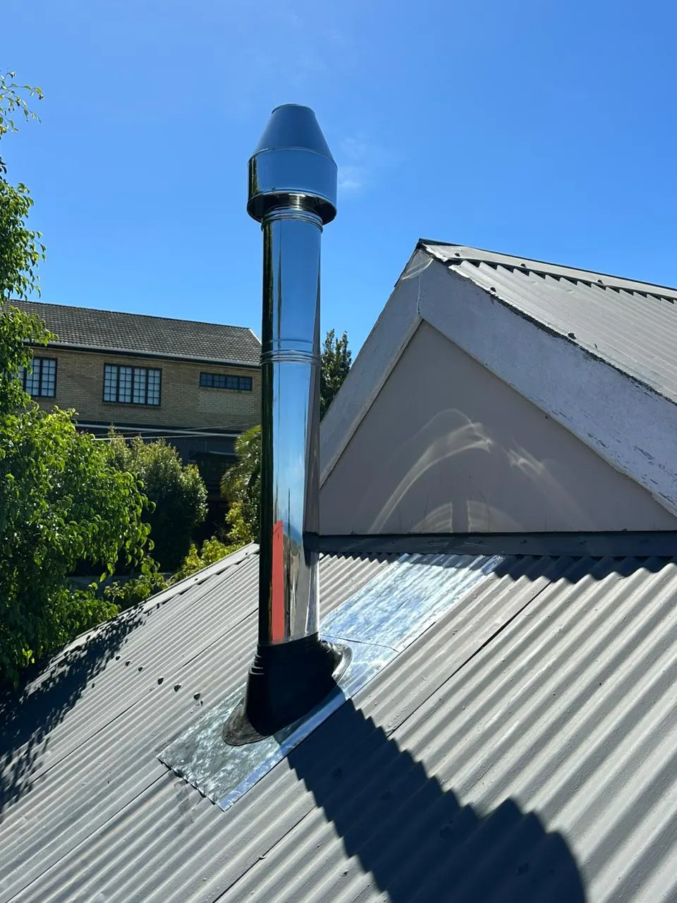 Stainless steel flue with flashing on a corrugated roof