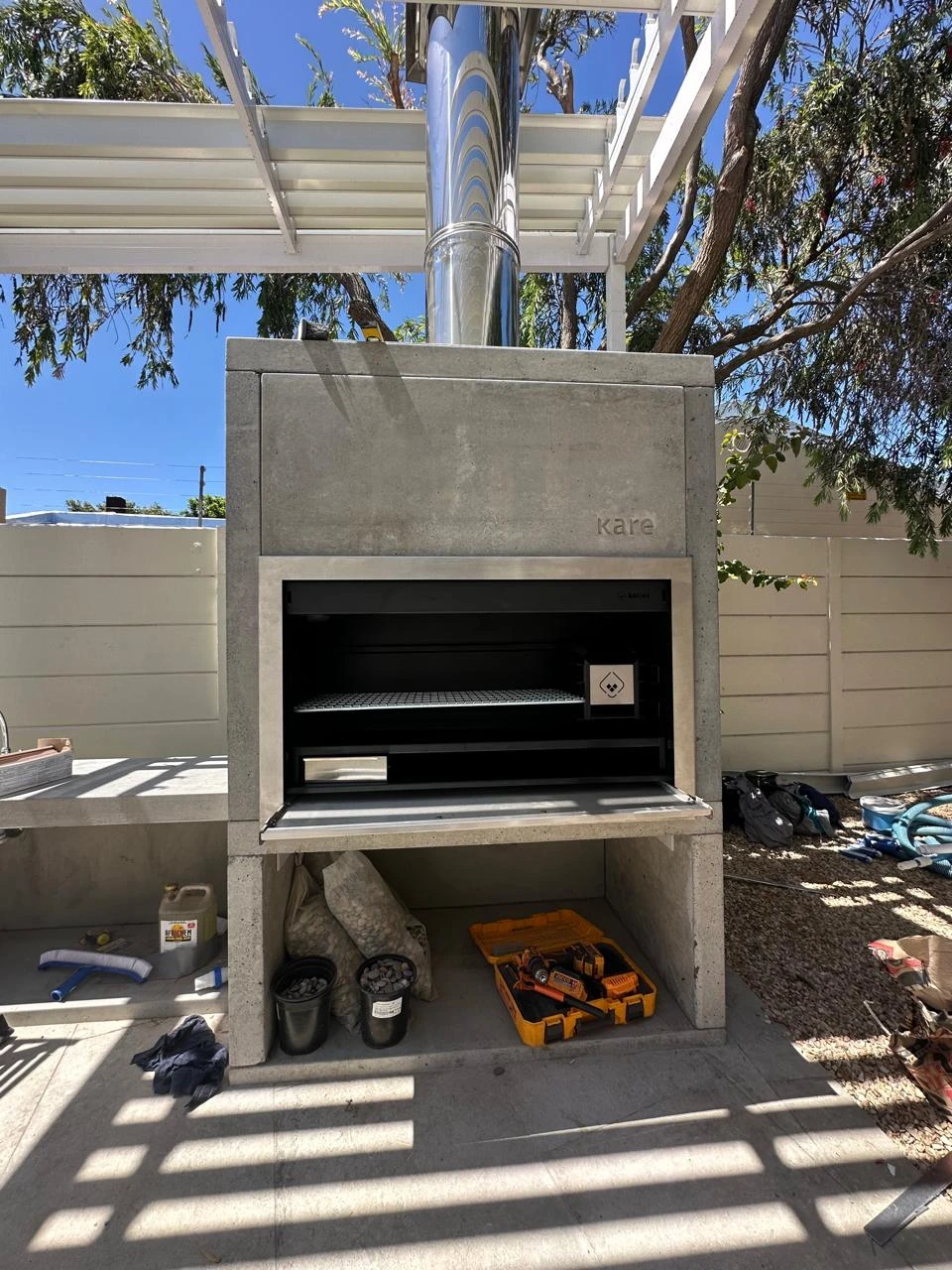 Braai surround and stainless-steel storage beneath a pergola