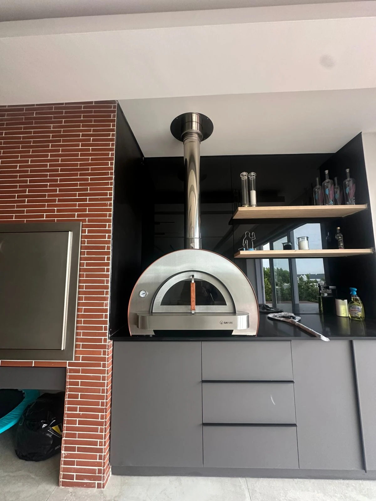 Pizza oven, worktop and shelving in an entertainment area