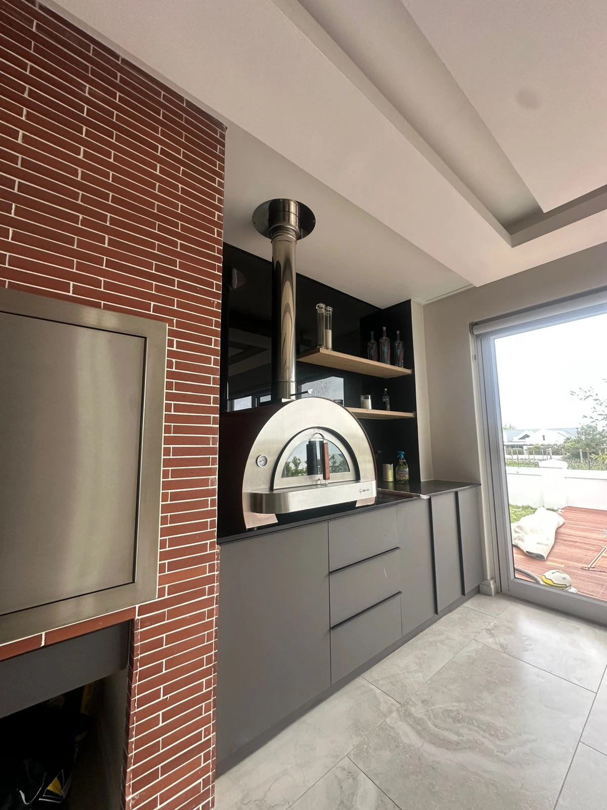 Pizza oven and braai viewed across the tiled entertainment room