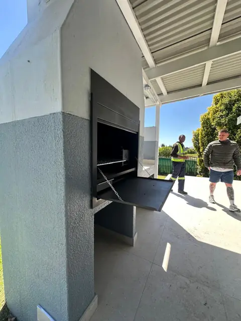 Side view of a built-in braai with its door open, Durbanville