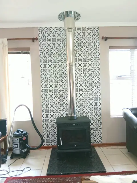 Freestanding fireplace and stainless steel flue on a granite hearth, Durbanville