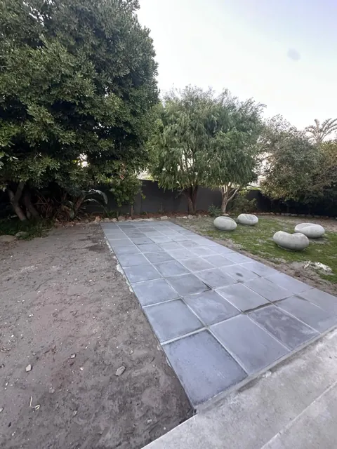 Paved garden path with decorative stones on the lawn