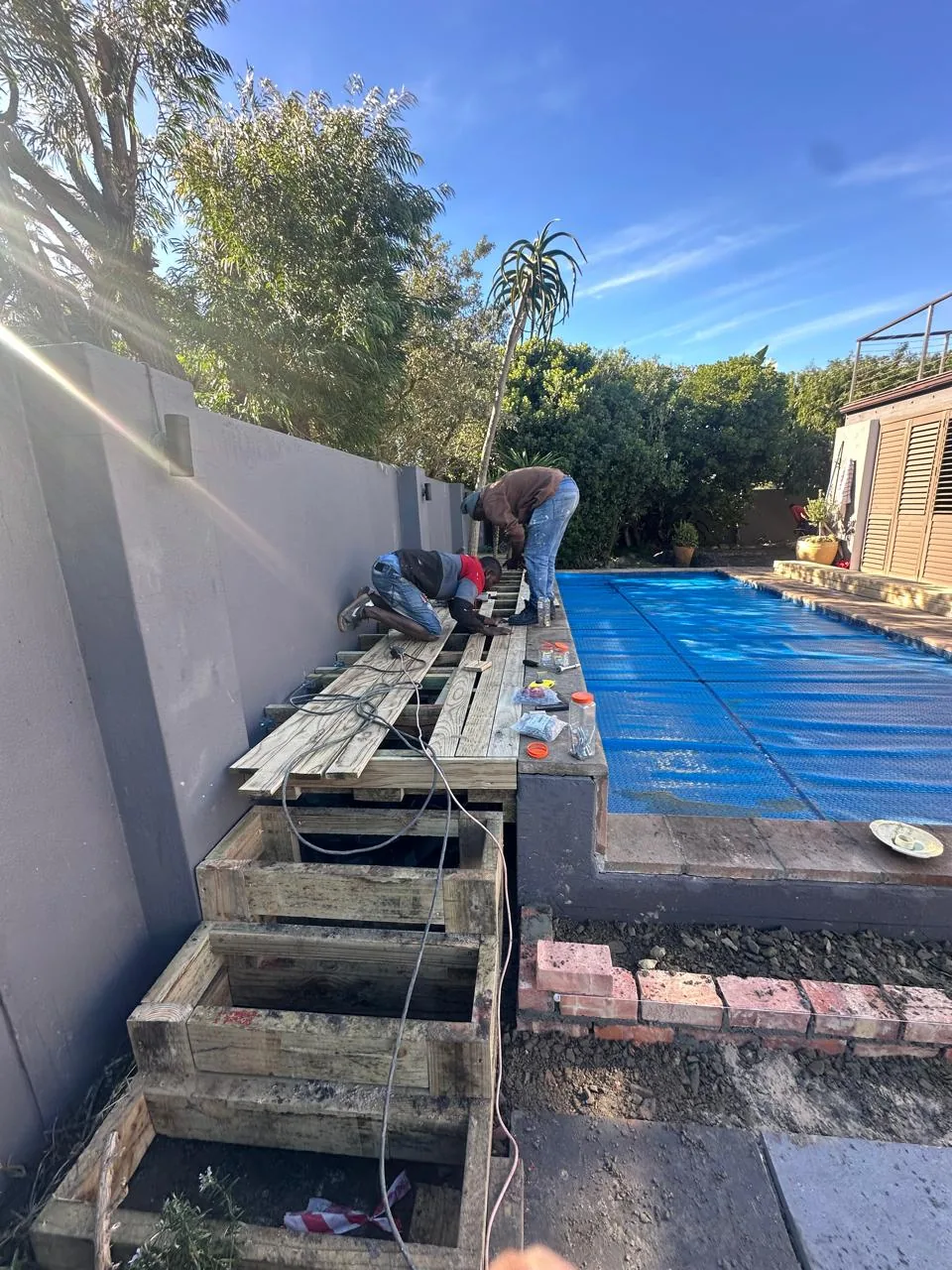 Fire Flames team building a timber deck frame next to a pool