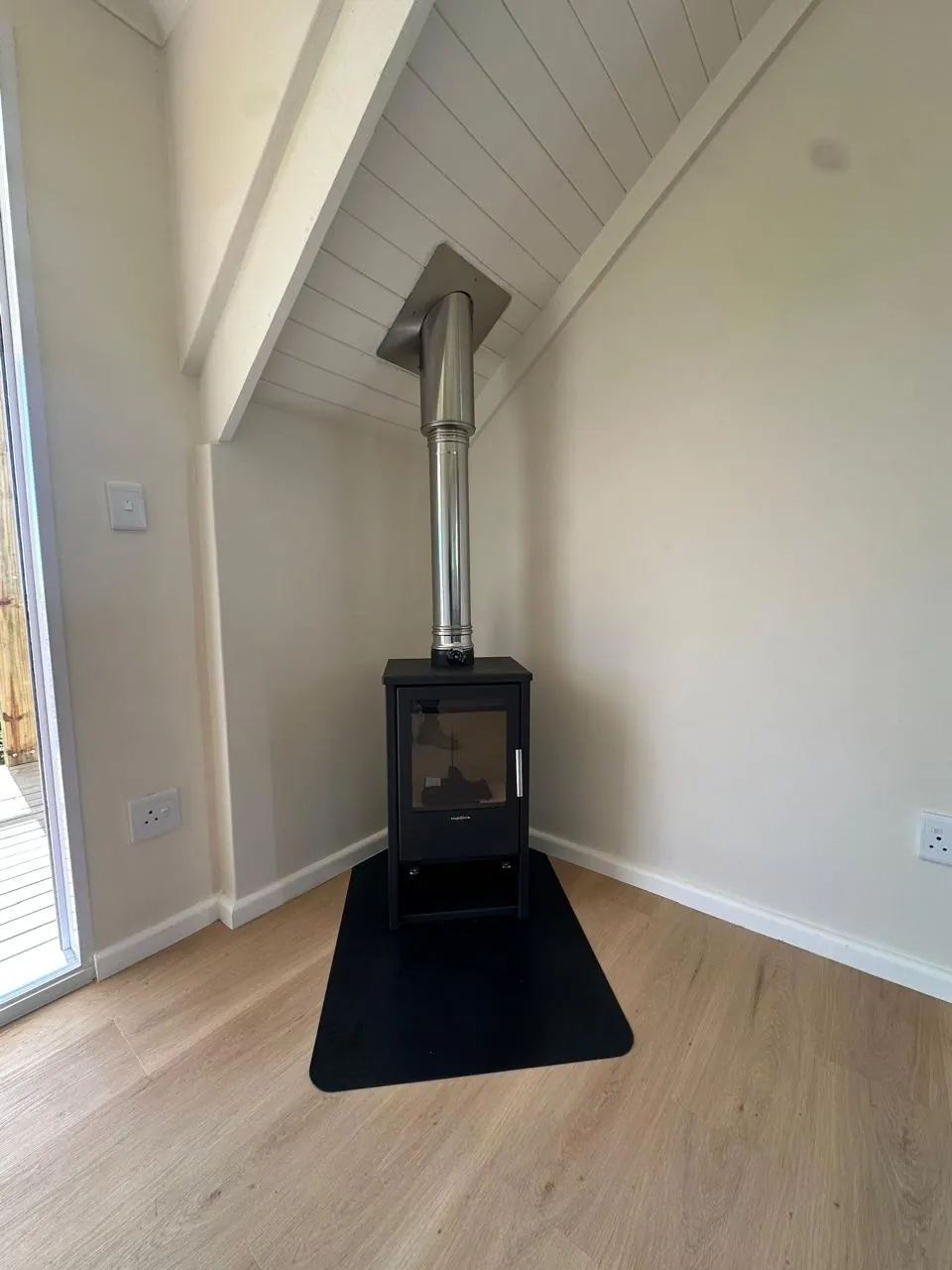 Freestanding fireplace installed under a raked ceiling in Kommetjie