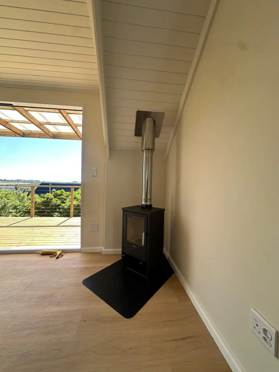 Fireplace and flue beside sliding doors onto the deck