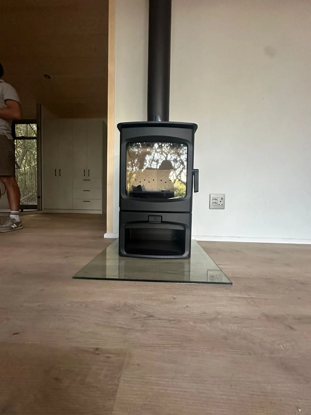 Curved-door Charnwood stove installed in an open-plan Noordhoek living room