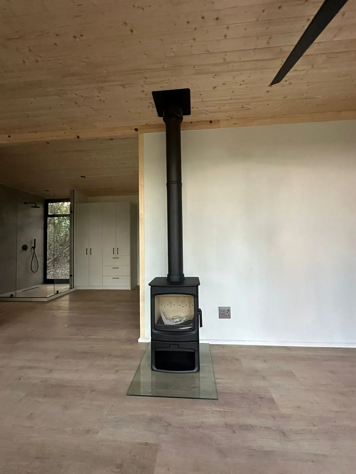 Charnwood stove and stainless flue against a white wall in Noordhoek