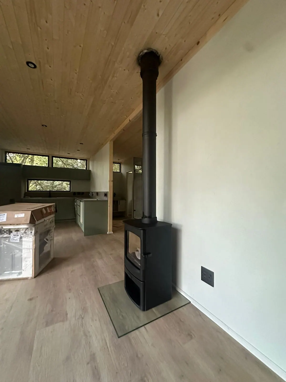 Freestanding fireplace beneath a raked timber ceiling in Noordhoek