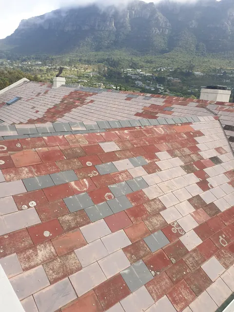 Faded, patchy red and grey roof tiles in Hout Bay before cleaning and painting