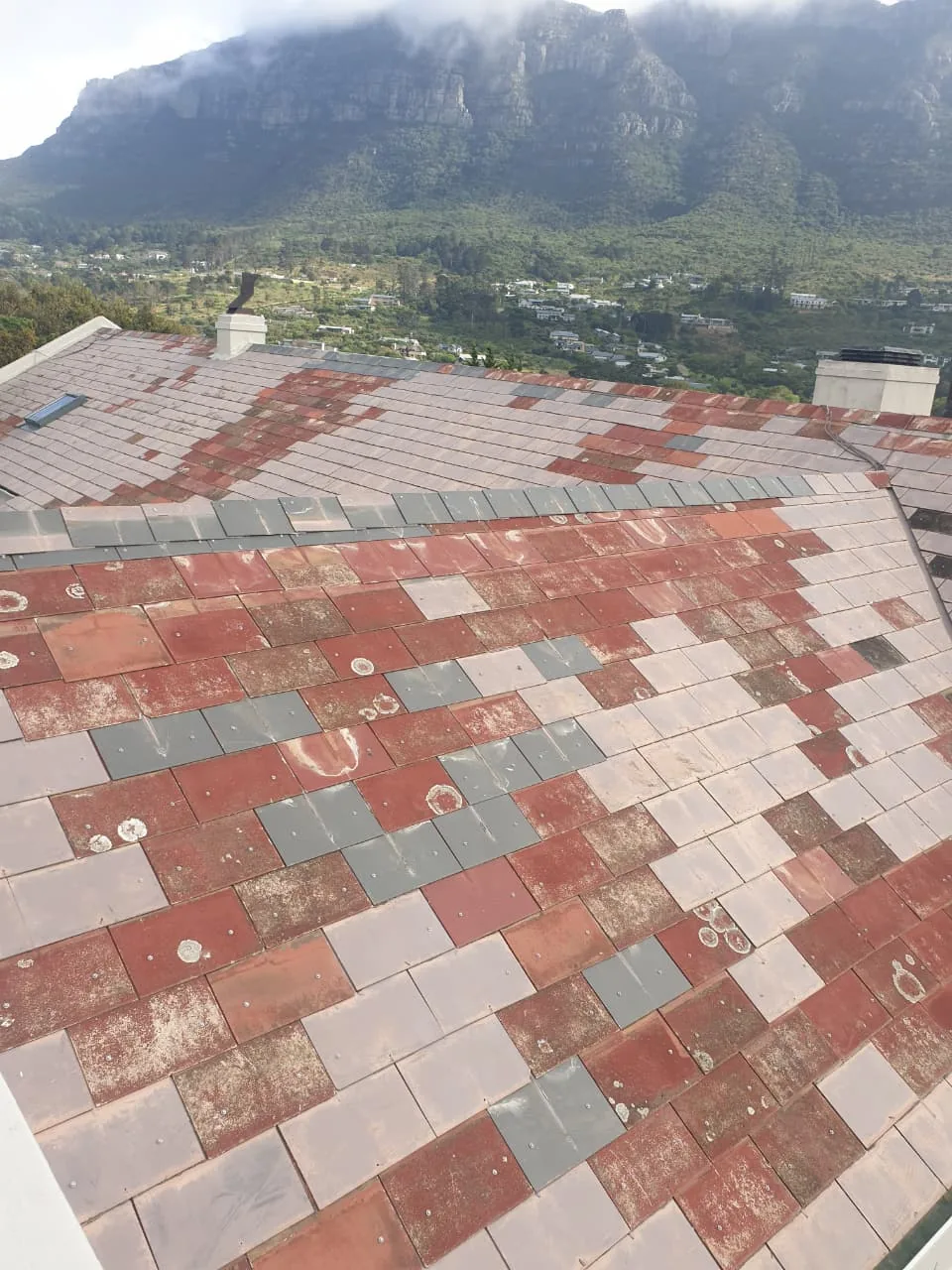 Faded, patchy red and grey roof tiles in Hout Bay before cleaning and painting