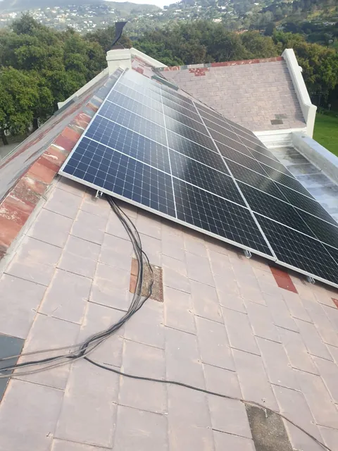 Faded roof tiles around solar panels in Hout Bay before painting