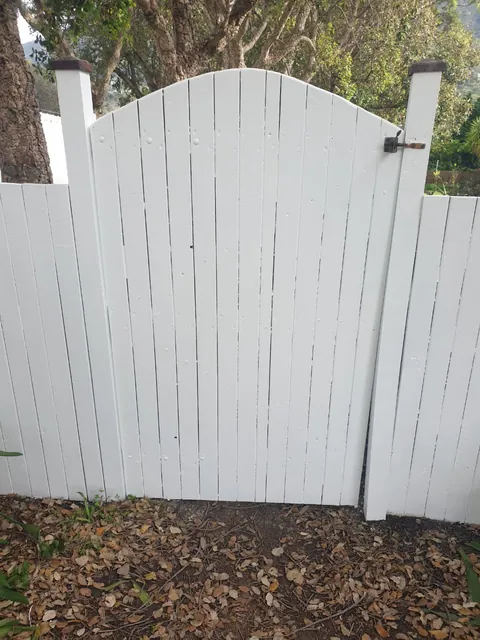 Wooden garden gate and fence painted white in Hout Bay